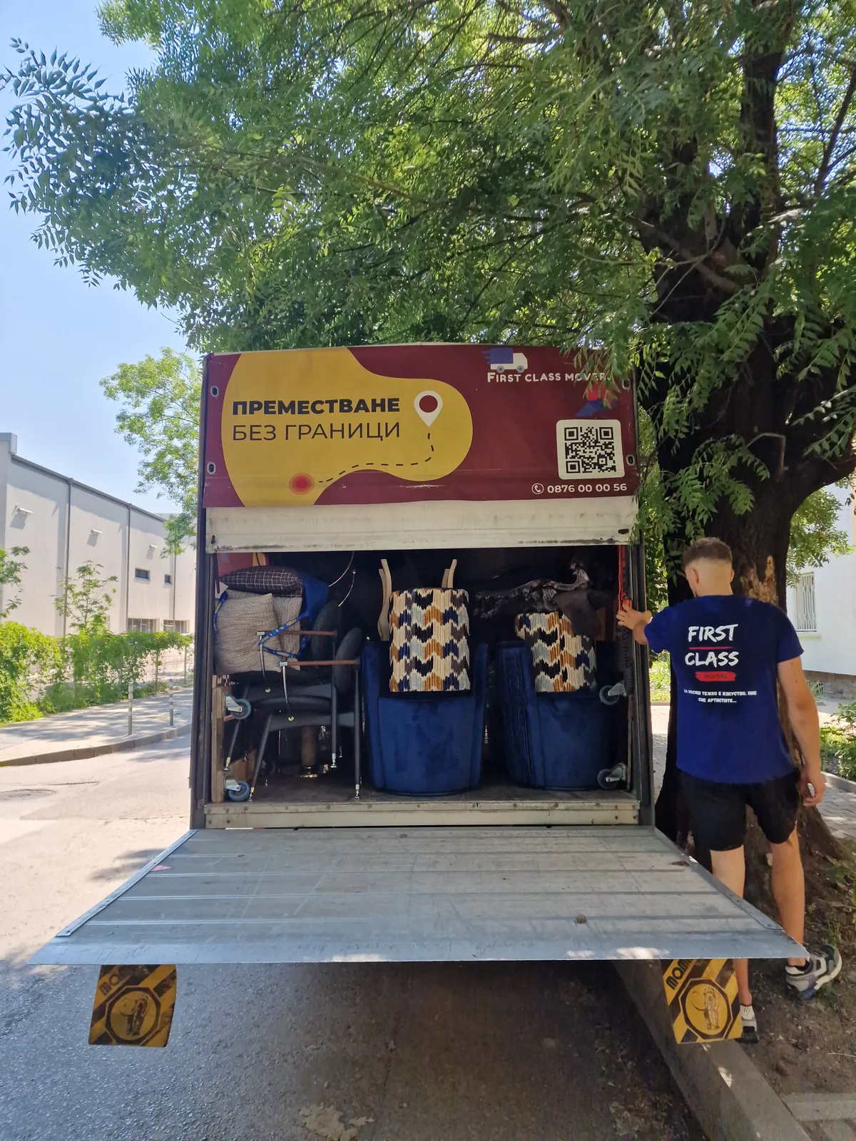 Натоварен камион на First Class Movers и хамалин при преместване на дом