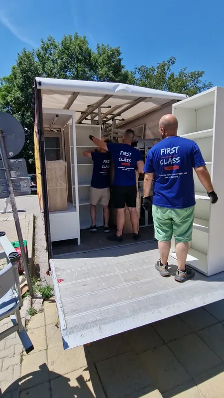 The team loading a wardrobe into a truck with a tail lift
